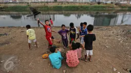 Anak-anak menghabiskan waktu bermain burung merpati di bantaran Kanal Banjir Barat (KBB), Tanah Abang, Jakarta, Jumat (9/10). Terbatasnya ruang publik menyebabkan anak-anak tersebut terpaksa bermain di bantaran kanal. (Liputan6.com/Immanuel Antonius)