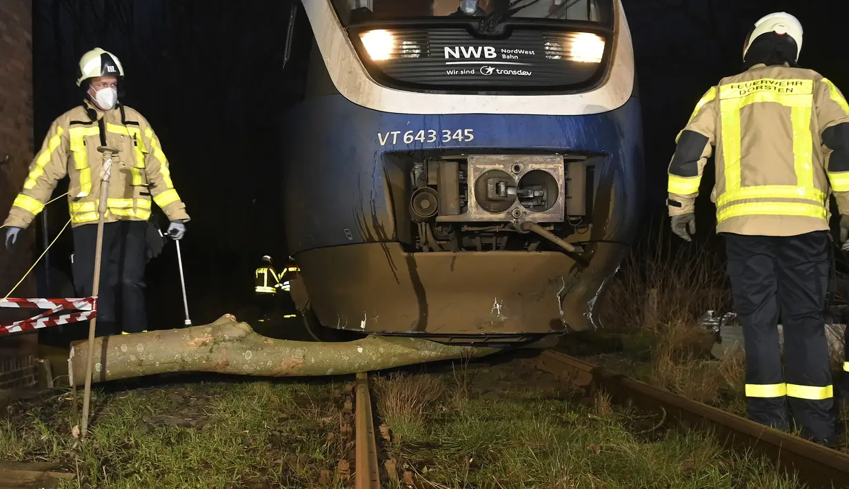 Petugas pemadam kebakaran membersihkan pohon dari rel kereta api setelah badai di Dorsten, Jerman, Kamis (17/2/2022). Deutsche Bahn telah menangguhkan layanan jarak jauh di beberapa wilayah Jerman karena badai. (Bludau Foto/dpa via AP)