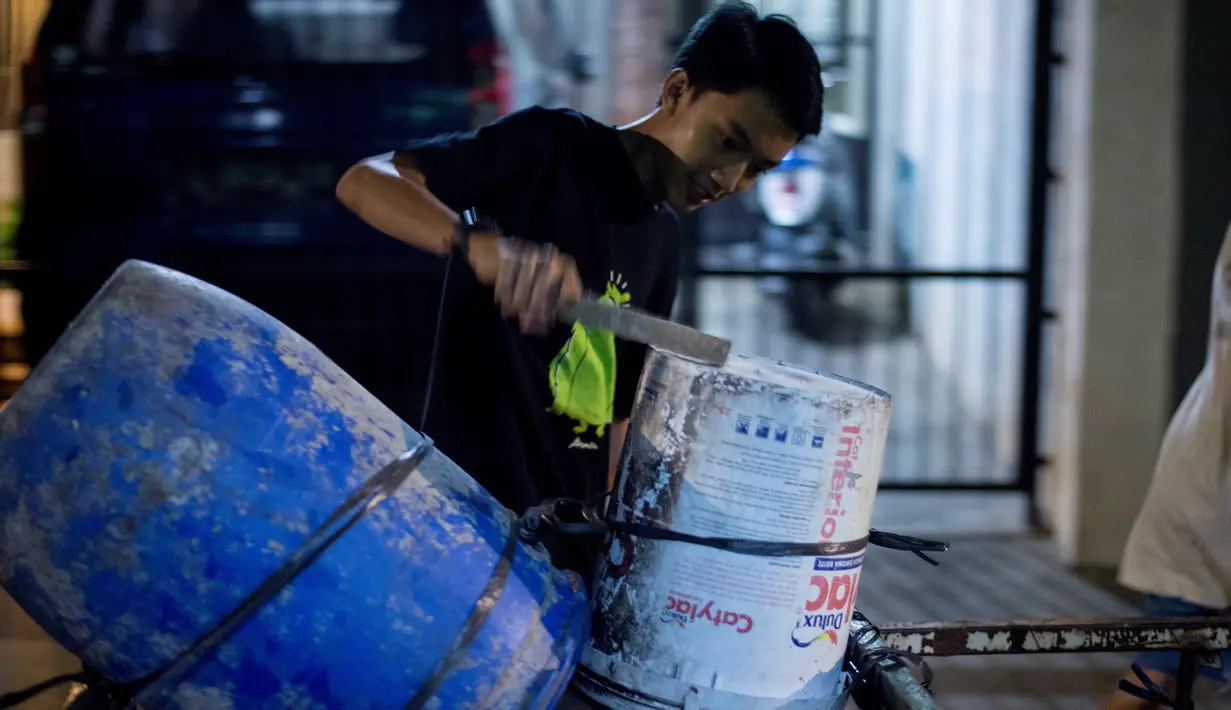 Foto yang diambil pada 19 Mei 2018, para pemuda bernyanyi dan memukul drum berkeliling sekitar lingkungan mereka di Jakarta. Kegiatan tersebut merupakan tradisi selama bulan ramadan membangunkan warga untuk sahur. (AFP PHOTO/BAY ISMOYO)