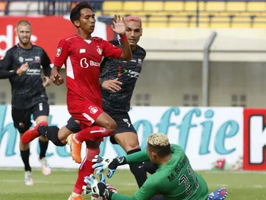 Penjaga gawang Madura United, Muhammad Ridwan berhasil mengamankan bola dari ancaman pemain Persik Kediri dalam laga Grup C Piala Menpora 2021 di Stadion Si Jalak Harupat, Bandung, Sabtu (3/4/2021). (Bola.com/Ikhwan Yanuar)