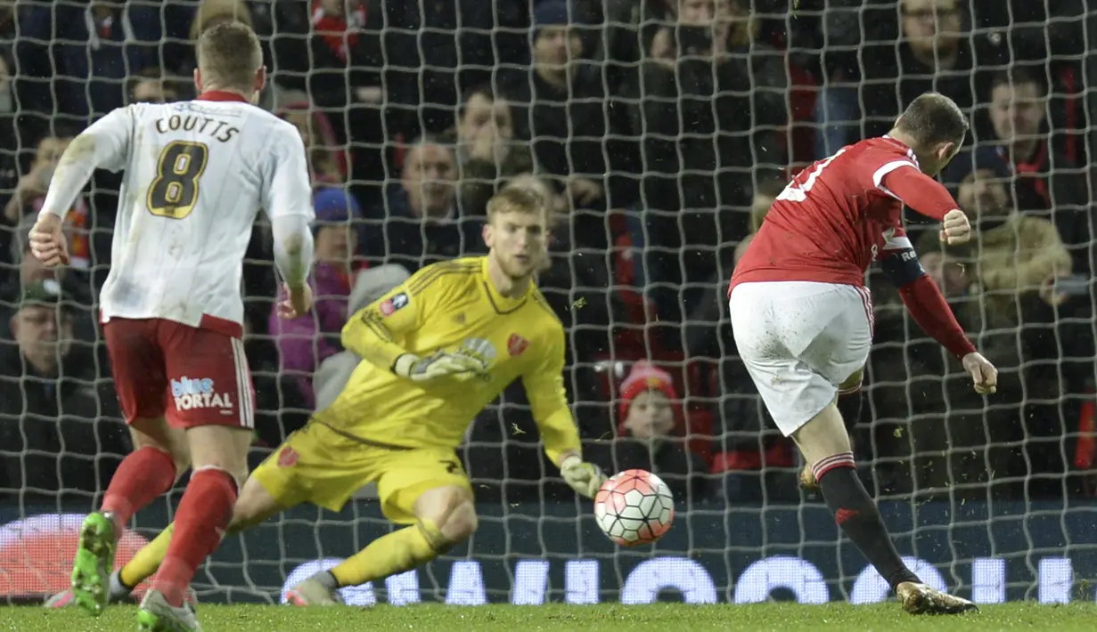 Manchester United, Wayne Rooney (kanan) saat mencetak gol lewat tendangan penalty pada laga Piala FA di Old Trafford, Minggu (10/1/2016) dini hari WIB. (AFP Photo/Oli Scarff)