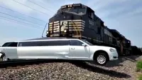 Sebuah mobil limousine tersangkut di atas rel kereta api karena badan mobilnya terlalu panjang. 