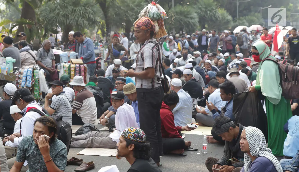 Pedagang asongan menawarkan dagangannya di sela-sela massa aksi di sekitaran Jalan Medan Merdeka Barat, Jakarta, Kamis (27/6/2019). Massa yang melakukan aksi terkait sidang putusan perselisihan hasil Pilpres 2019 memberi keuntungan bagi para pedagang. (Liputan6.com/Helmi Fithriansyah)