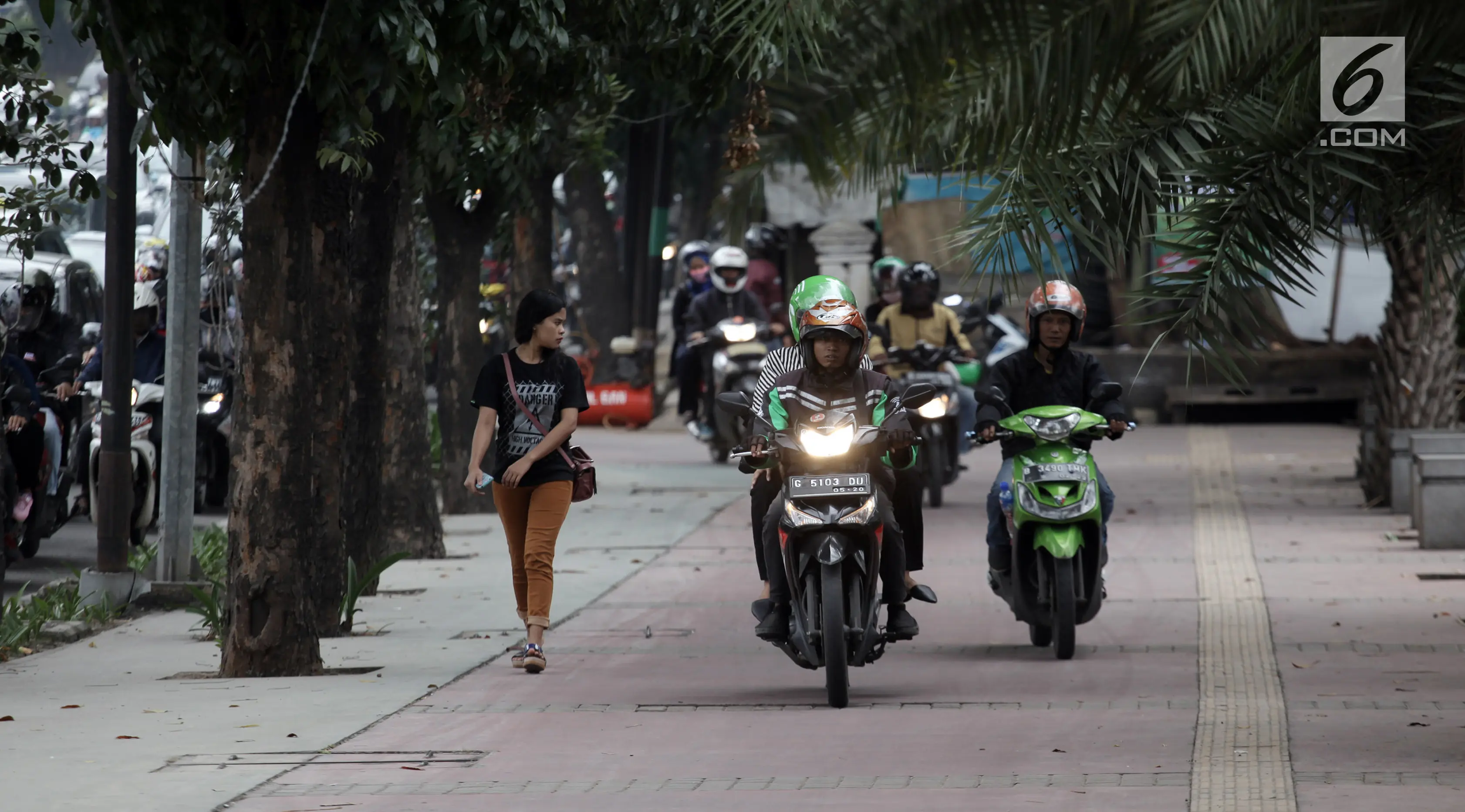 Sejumlah pengendara sepeda motor nekat menaiki jalur trotoar untuk menghindari kemacetan di Jalan Casablanca, Jakarta, Senin (8/1) (Liputan6.com/Arya Manggala Nuswantoro)