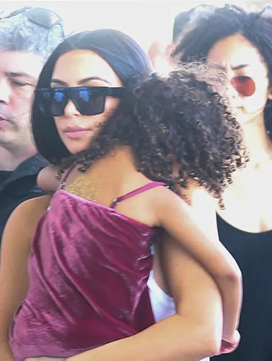 Meskipun menggunakan sepatu booth heelsnya, Kim tampak santai berlenggang sambil menggendong kedua buah hatinya di lengan sisi sebelah kanan dan kirinya. Tak terlihat lelah, Kim tampak menikmati perannya sebagai ibu. (doc.dailymail.com)