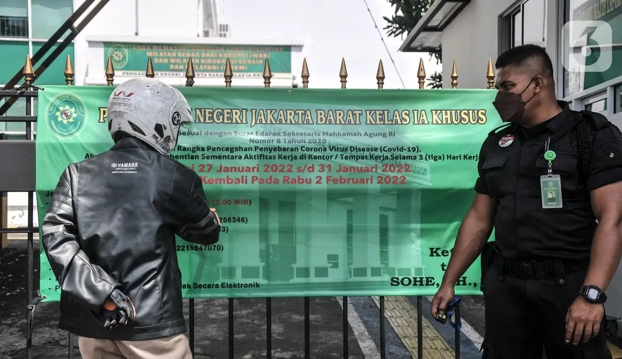 Petugas keamanan memberitahukan kepada pengunjung terkait penutupan sementara PN Jakarta Barat, Kamis (27/1/2022).   Penutupan dilakukan menyusul temuan kasus 13 orang yang terdiri dari hakim dan pegawai di Pengadilan Negeri Jakarta Barat positif terpapar Covid-19. (Merdeka.com/Iqbal S. Nugroho)