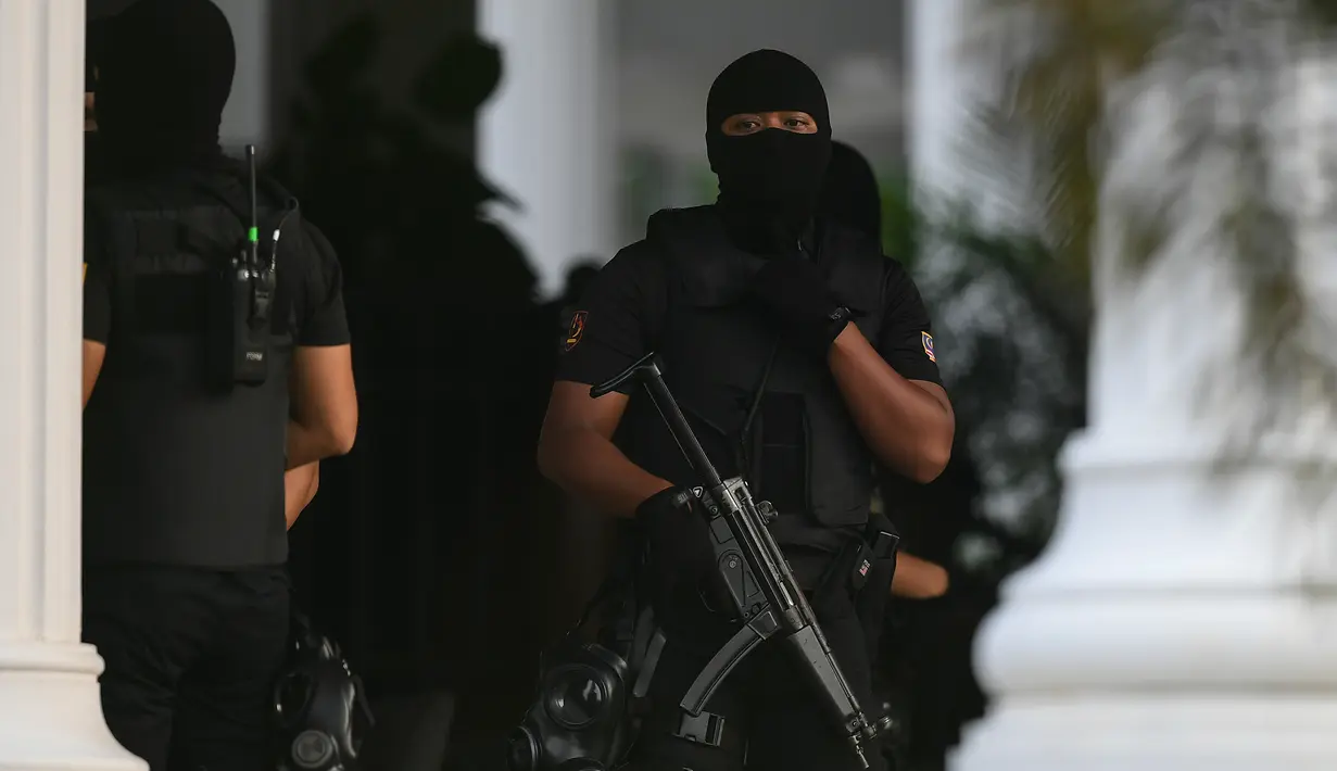 Aparat polisi bersenjata dengan menggunakan penutup wajah bersiaga di dalam Gedung Mahkamah Sepang, Kamis (13/4). Sidang terdakwa pembunuhan Kim jong-Nam, Siti Aisyah dan Doan Thi Huong di bawah penjagaan ketat aparat keamanan. (AP Photo/Vincent Thian)