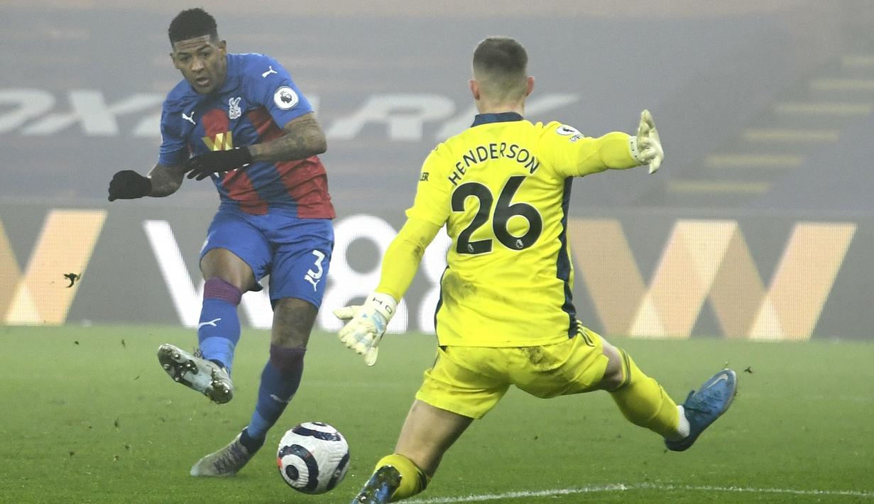 Bek Crystal Palace, Patrick van Aanholt berusaha memasukan bola ke gawang yang dijaga kiper Manchester United, Dean Henderson pada pertandingan lanjutan Liga Inggris di stadion Selhurst Park di London, Kamis (4/3/2021). MU bermian imbang atas Crystal Palace 0-0. (Mike Hewitt/Pool via AP)