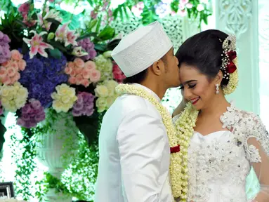 Hengky Kurniawan saat mencium kening Sonya Fatmala usai melangsungkan akad nikah di sebuah hotel kawasan TMII, Jakarta, Kamis (23/4/2015). (Liputan6.com/Panji Diksana)