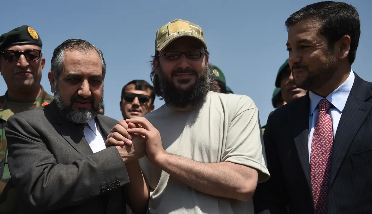 Putra mantan PM Pakistan Yusuf Raza Gilani, Ali Haider Gilani berjabat tangan dengan Dubes Pakistan untuk Afghanistan, Syed Abrar Hussain saat tiba di Kabul, Rabu (11/5). Ali Haider berhasil dibebaskan setelah diculik sejak 2013 lalu. (Wakil KOHSAR/AFP)