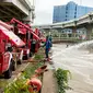 Petugas pemadan kebakaran menyedot air banjir di kawasan Cipinang Melayu, Jakarta, Minggu (21/2/2021). Suku Dinas Pemadam Kebakaran Jakarta Timur mengerahkan 20 mobil pompa untuk menyedot air yang membanjiri RW 04 Kelurahan Cipinang Melayu untuk mengurangi debit air. (Liputan6.com/Faizal Fanani)