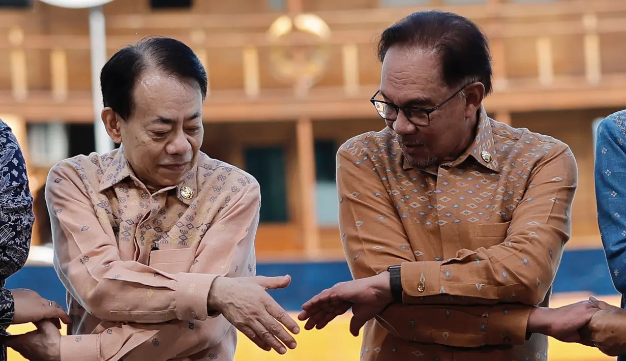 Sementara itu, PM Malaysia Anwar Ibrahim memakain kemeja tenun bewarna cokelat. (Willy Kurniawan/Pool Photo via AP)