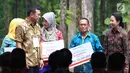 Menteri BUMN Rini Soemarno (kanan) menyalurkan KUR kepada petani penggarap lahan hutan melalui Program Perhutanan Sosial di Tuban, Jawa Timur, Jumat (9/3). Pemerintah menyalurkan KUR, Kartu Tani, dan CSR BNI. (Liputan6.com/Angga Yuniar)