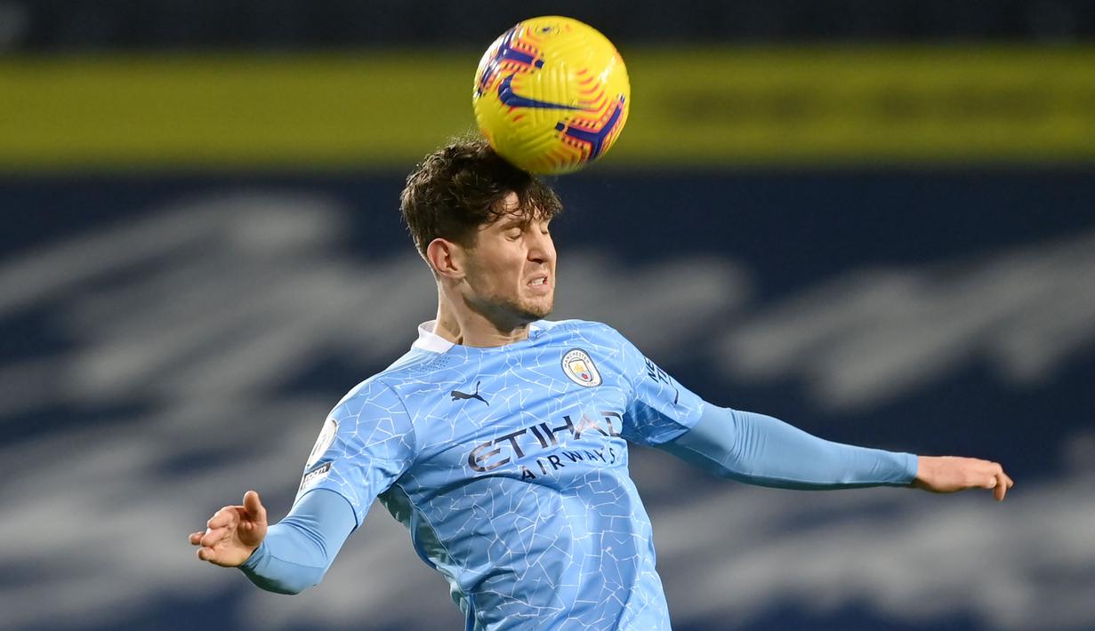 Bek Manchester City, John Stones, menyundul bola saat melawan West Bromwich Albion pada laga Liga Inggris di Stadion The Hawthorns, Selasa (27/1/2021). City menang dengan skor 0-5. (Michael Regan/POOL/AFP)