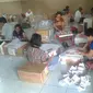 Warga setempat melipat surat suara untuk Pilkada di Papua. (Katharina Janur/Liputan6.com)