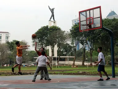 Sejumlah pelajar bermain basket di Kawasan Lapangan Banteng, Jakarta, Senin (29/8). Pemprov DKI Jakarta berencana melakukan desain ulang Lapangan Banteng, sehingga Monumen Pembebasan Irian Barat bisa lebih terlihat. (Liputan6.com/Helmi Fithriansyah)