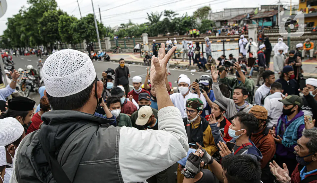 Massa pendukung Rizieq Shihab memintas rekannya membubarkan diri di flyover Penggilingan, Jakarta, Kamis (24/6/2021). Sebelumnya, polisi dengan para simpatisan Rizieq Shihab terlibat bentrokan jelang sidang vonis perkara tes swab yang digelar di di PN Jakarta Timur. (Liputan6.com/Faizal Fanani)