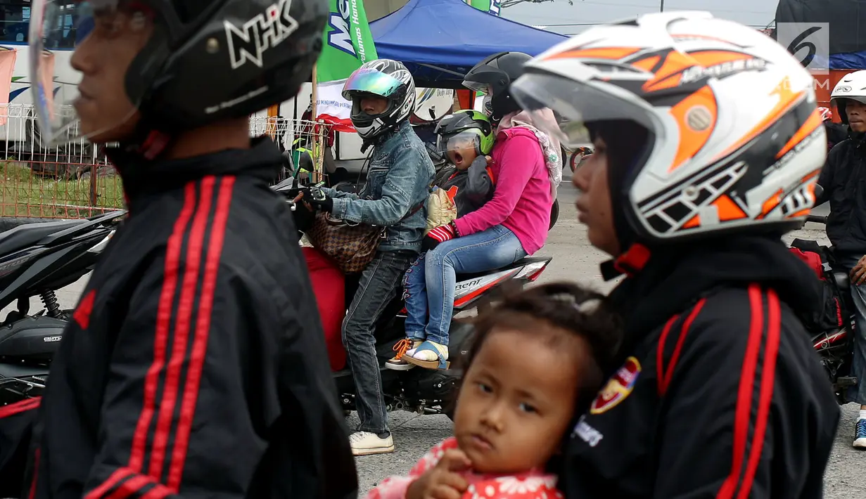 Pemudik sepeda motor dengan membawa anak mengantre untuk mengisi bahan bakar di SPBU kawasan Pantura di wilayah Brebes, Jawa Tengah, Kamis (22/6). Meski berbahaya, sejumlah pemudik masih nekat membawa anak mereka dengan motor. (Liputan6.com/Johan Tallo)