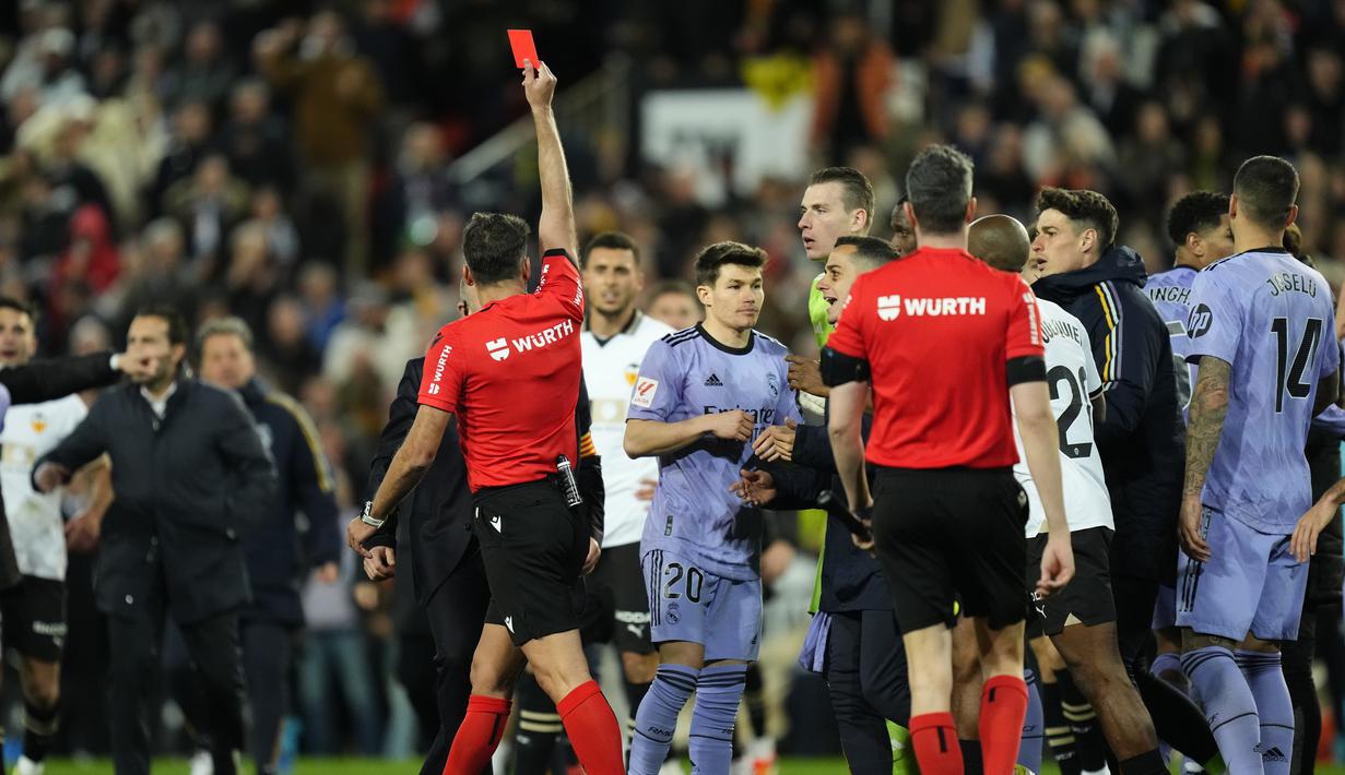 Wasit Gil Manzano memberikan kartu merah kepada pemain Real Madrid, Jude Bellingham, saat melawan Valencia pada laga Liga Spanyol pekan ke-27 di Stadion Mestalla, Minggu (3/3/2024). (AP Photo/Jose Breton)