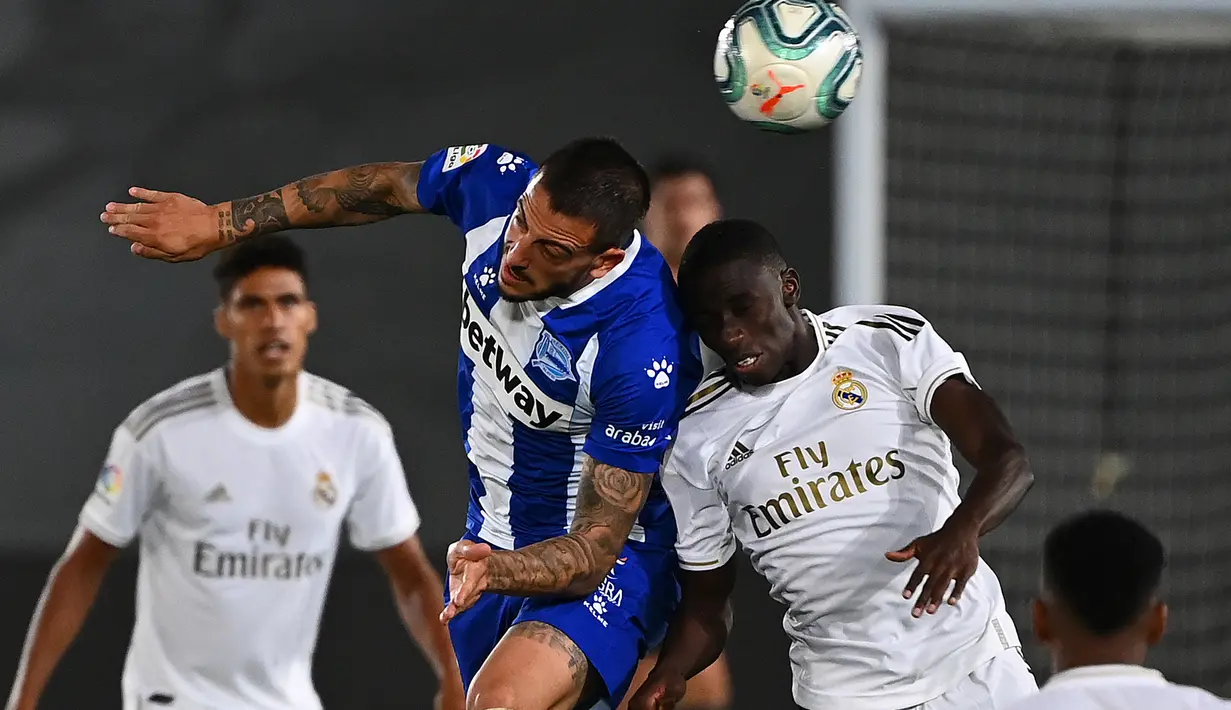 Penyerang Alaves, Joselu berebut bola dengan bek Real Madrid, Ferland Mendy pada lanjutan Liga Spanyol di stadion Alfredo di Stefano, Sabtu (11/7/2020). Real Madrid menang 2-0 lewat gol Karim Benzema dan Marco Asensio. (GABRIEL BOUYS/AFP)