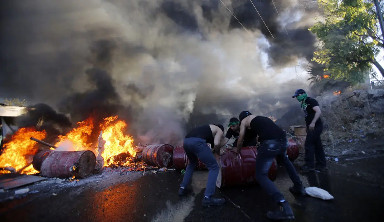 Warga Palestina menutup jalan utama antara Bethlehem dan Hebron pasca terjadi bentrokan dengan militer Israel di Beit Ommar, utara kota Hebron, (25/7/2014). (REUTERS/Mussa Qawasma)