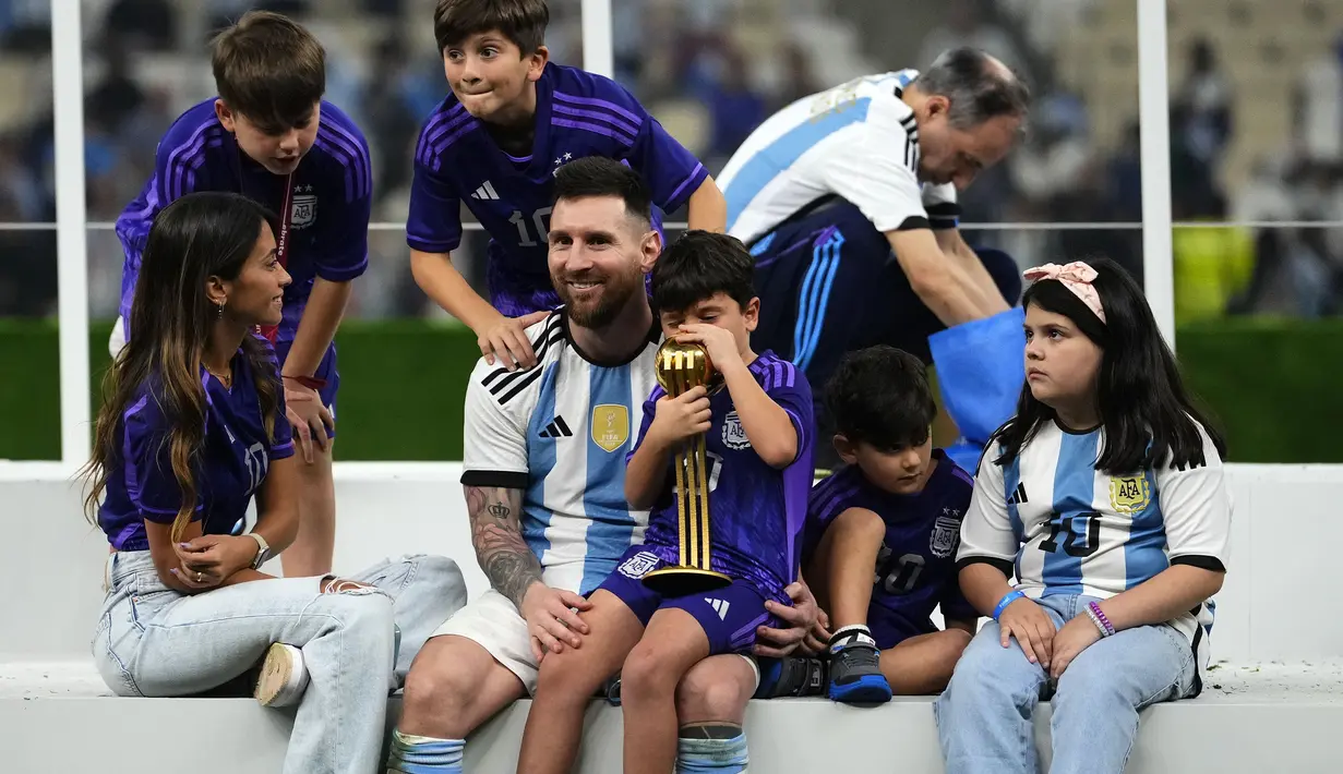 Pemain Argentina, Lionel Messi merayakan kemenangan timnya di Piala Dunia 2022 bersama keluarganya setelah mengalahkan Prancis pada laga final yang berlangsung di Lusail Stadium, Qatar, Minggu (18/12/2022). Albiceleste menang 4-2 atas Prancis di babak penalti. (AP Photo/Manu Fernandez)