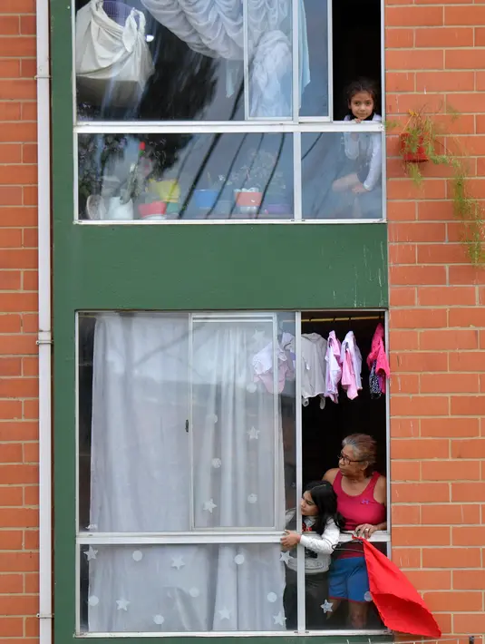 Orang-orang menggantungkan kain merah di rumah mereka untuk meminta bantuan makanan selama lockdown di kotamadya Soacha, dekat Bogota, 4 April 2020. Presiden Kolombia Ivan Duque menetapkan lockdown dari 24 Maret hingga 13 April sebagai langkah mencegah penyebaran virus corona. (Raul ARBOLEDA/AFP)