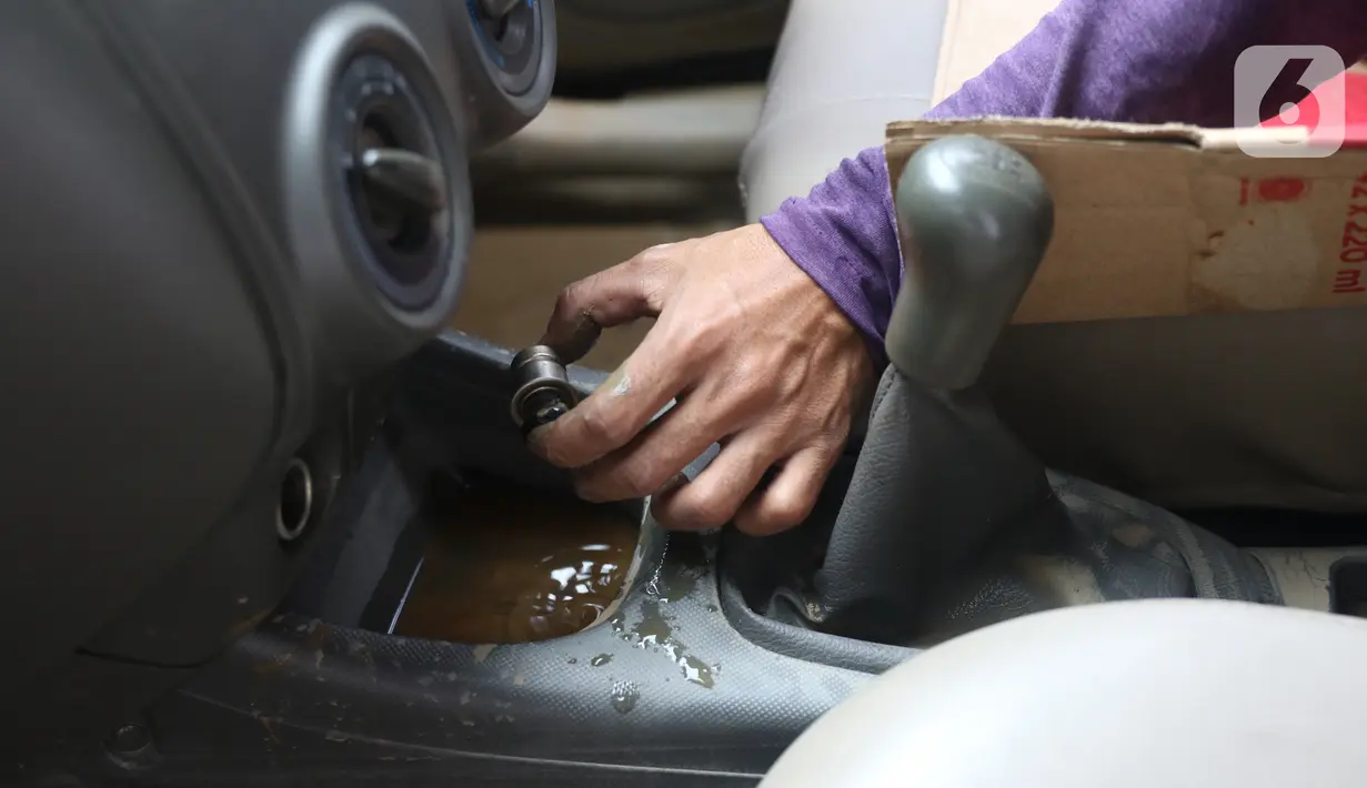Mekanik mengecek komponen mobil yang terendam banjir di sebuah bengkel di Jakarta, Rabu (8/1/2020). Kerusakan pada mobil yang terendam banjir meliputi interior, kabel dan kelistrikan, serta bagian mesin. (Liputan6.com/Angga Yuniar)