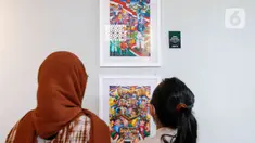 Pengunjung menyaksikan karya lukis yang bertajuk 'Membangun Harmoni' di Museum Basoeki Abdullah, Jakarta, Sabtu (18/12/2021). 'Membangun Harmoni' tersebut merupakan hasil karya lomba dari pelajar di tingkat SD, SMP, hingga SMA. (Liputan6.com/Herman Zakharia)