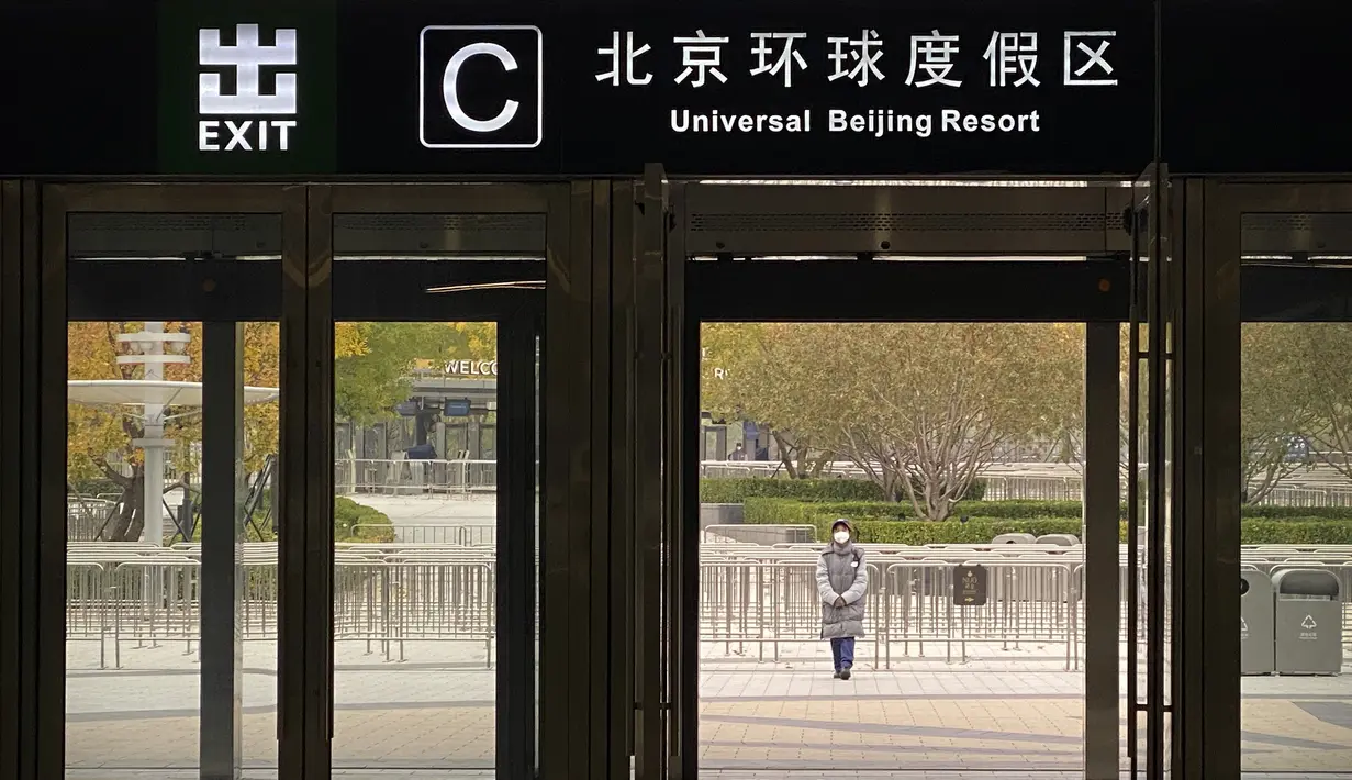 Seorang pekerja yang mengenakan masker berdiri di luar pintu keluar dari stasiun kereta bawah tanah untuk menghentikan pengunjung pergi ke resor Universal Studios Beijing, yang menurut pemberitahuan ditutup untuk pengendalian epidemi, di Beijing, Rabu (26/10/2022). Kota Shanghai di China mulai memberikan vaksin COVID-19 yang dapat dihirup pada hari Rabu di tempat yang tampaknya menjadi yang pertama di dunia. (AP/Mark Schiefelbein)