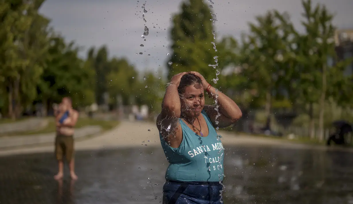 Seorang wanita mendinginkan tubuhnya di pantai perkotaan taman Madrid Rio di Madrid, Spanyol, Rabu, 12 Juli 2023. (AP Photo/Manu Fernandez)