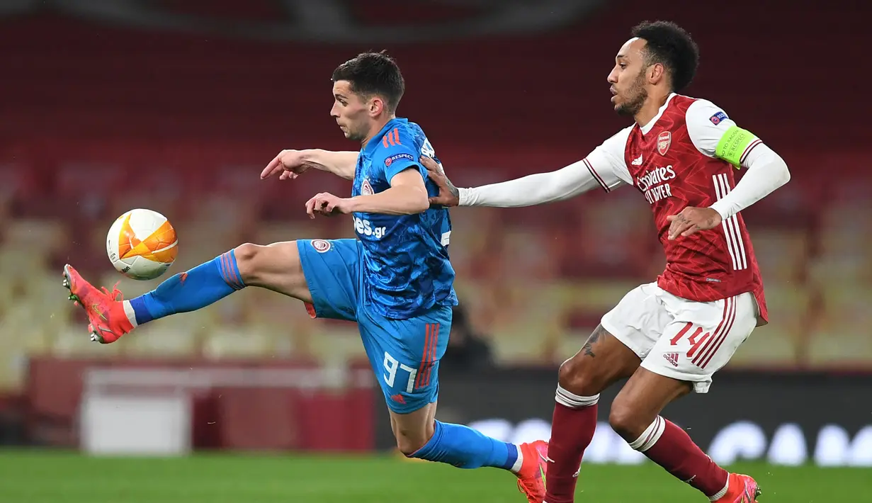 Striker Olympiakos, Lazar Randelovic (kiri) menguasai bola dibayangi striker Arsenal, Pierre-Emerick Aubameyang melakukan dalam laga leg kedua babak 16 besar Liga Europa 2020/2021 di Emirates Stadium, London, Kamis (18/3/2021). Olympiakos menang 1-0 atas Arsenal. (AFP/Daniel Leal-Olivas)