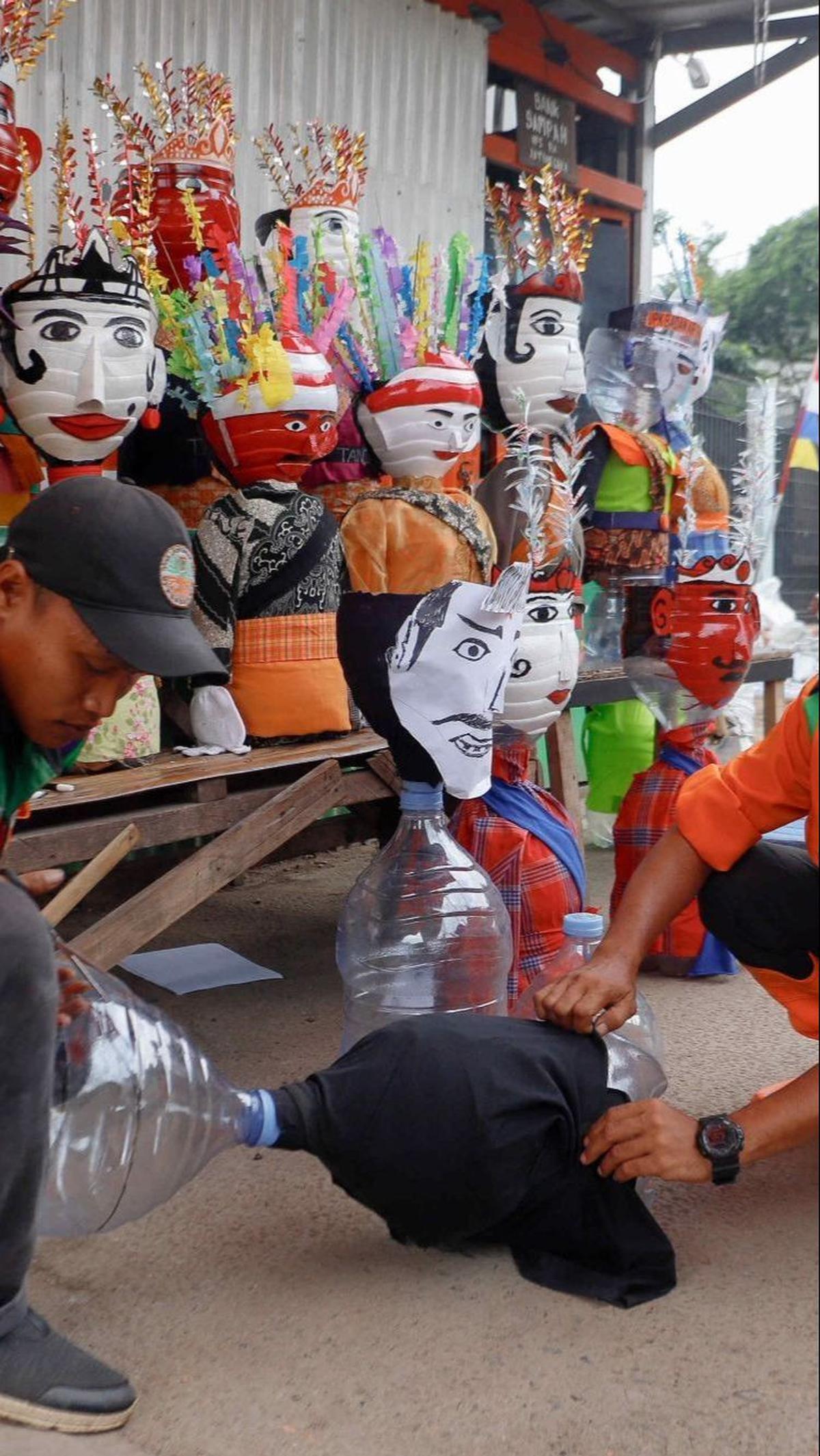 Dalam upaya mengurangi limbah plastik dan meningkatkan kesadaran lingkungan di kalangan masyarakat, mereka menciptakan ondel-ondel mini dari galon air minum bekas. Foto: Liputan6.com / Herman Zakharia<br>