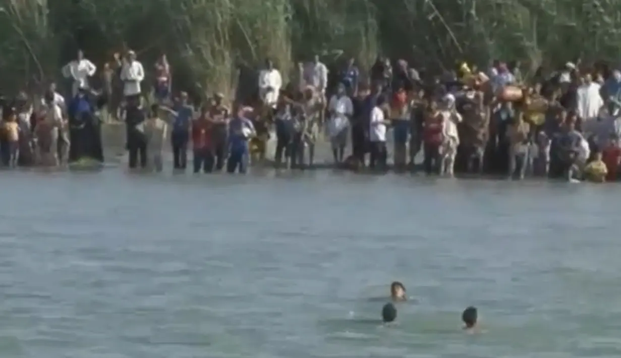 Sebuah gambar dari video yang dirilis Senin (6/6) menunjukkan warga Fallujah mencoba melarikan diri dengan menyebrangi Sungai Eufrat, untuk bisa keluar dari kota yang digempur pasukan pemerintah Irak, 3 Juni 2016. (REUTERS TV)