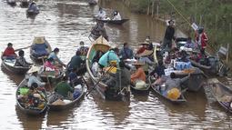 Penjual di atas kapal menjual makanan kepada pengunjung di pasar terapung lokal di Danau Inle yang terkenal, Negara Bagian Shan selatan, Myanmar,  Sabtu (15/1/2022). Ada sekitar 70 ribu jiwa populasi masyarakat Intha yang hidup di sepanjang aliran Danau Inle. (AP Photo)