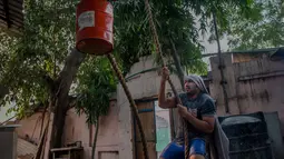 Seorang pegulat menarik beban saat mengikuti sesi latihan harian di semacam asrama gulat di Sabzi Mandi, New Delhi (20/11). Gulat tradisional atau Kushti ini hampir ditinggalkan peminatnya karena tergerus memodernisasi di India. (AP Photo/Dar Yasin)