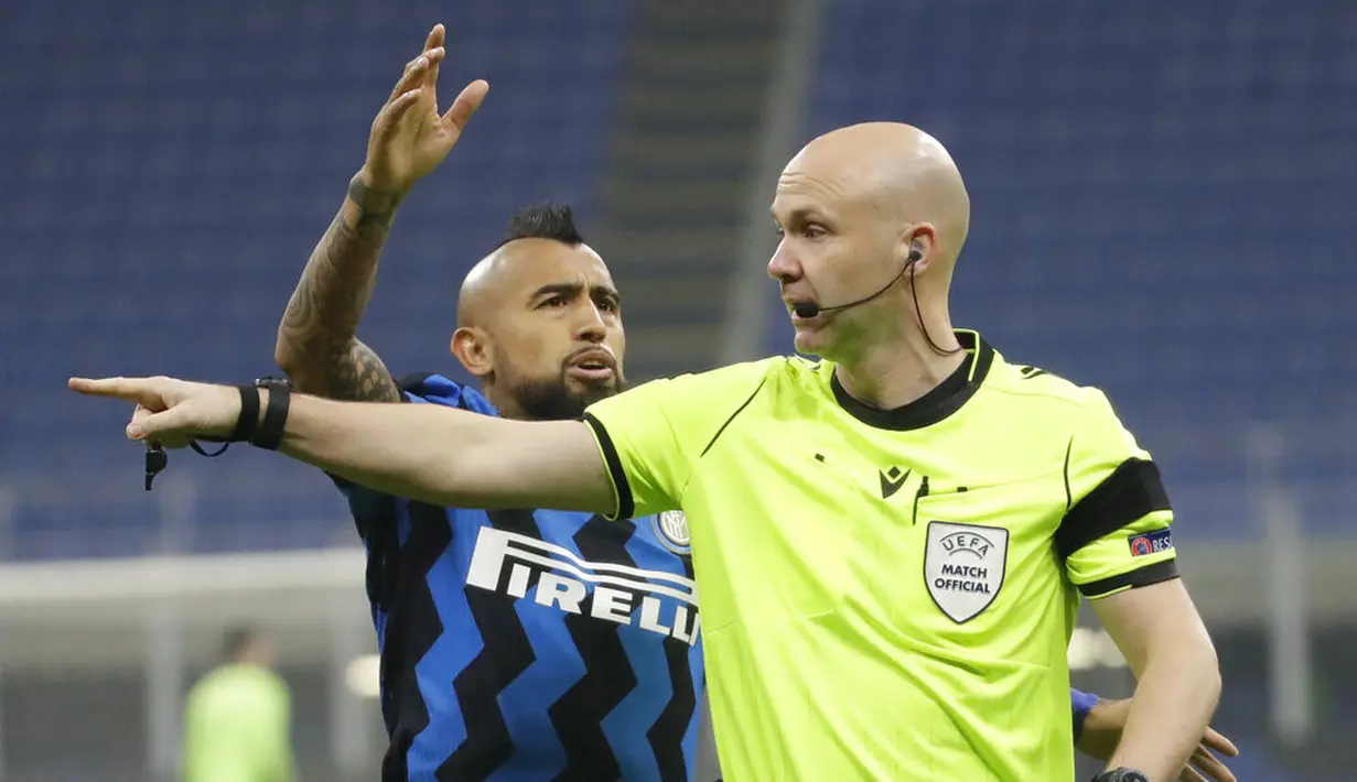 Pemain Inter Milan Arturo Vidal (kiri) berdebat dengan wasit Anthony Taylor saat melawan Real Madrid pada pertandingan Grup B Liga Champions di Stadion San Siro, Milan, Italia, Rabu (25/11/2020). Real Madrid melumat Inter Milan 2-0. (AP Photo/Luca Bruno)