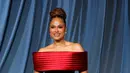 Ava DuVernay mengenakan gaun kolom off-shoulder berbahan beludru hitam dengan detail garis leher satin berwarna burgundy. [Dok/Louis Vuitton].