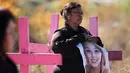 Carmen Castillo memegang foto mendiang putrinya Monica Delgado di pemakaman Juarez, Negara Bagian Chihuahua, Meksiko, (24/11). Aksi tersebut digelar jelang Hari Penghapusan Kekerasan Perempuan Internasional.(AFP Photo/Herika Martinez)