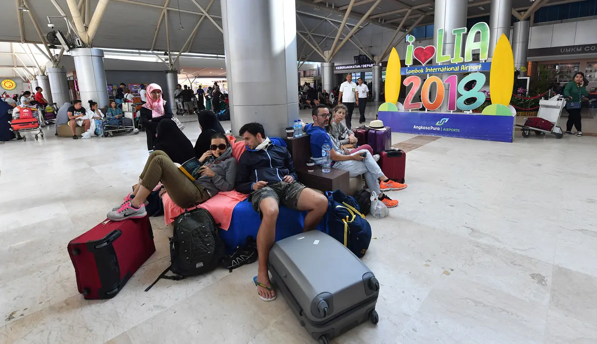 Wisatawan menunggu jadwal keberangkatan pesawat di Bandara Lombok Praya, pulau Lombok, Senin (6/8). Kegiatan operasional Bandara Lombok Praya saat ini sudah kembali normal setelah gempa sebesar 7 SR yang menewaskan 89 orang tersebut. (AFP/Adek BERRY)