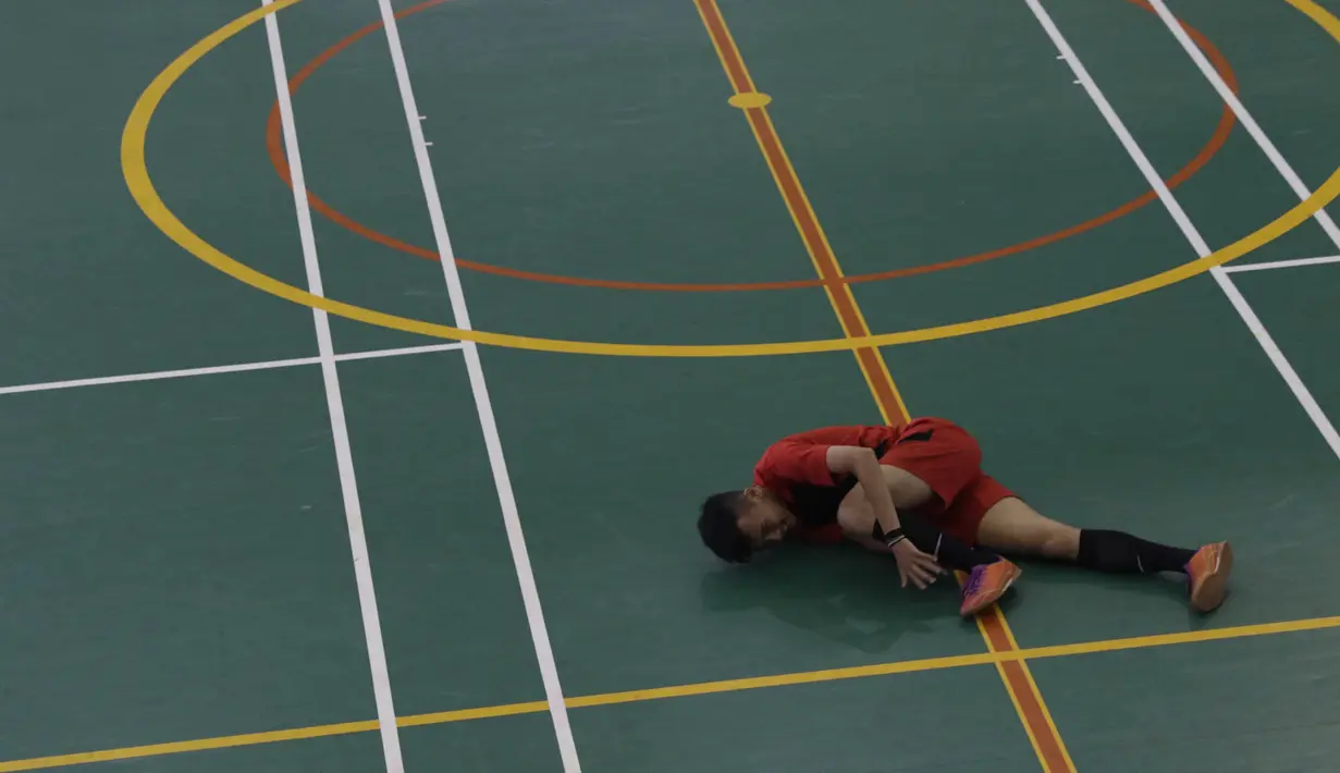 Seorang pesepak bola tuna rungu terjatuh saat bertanding pada Kejuaraan Futsal Tuna Rungu di GOR Ciracas, Jakarta, Sabtu (7/11/2015). (Bola.com/Vitalis Yogi Trisna)