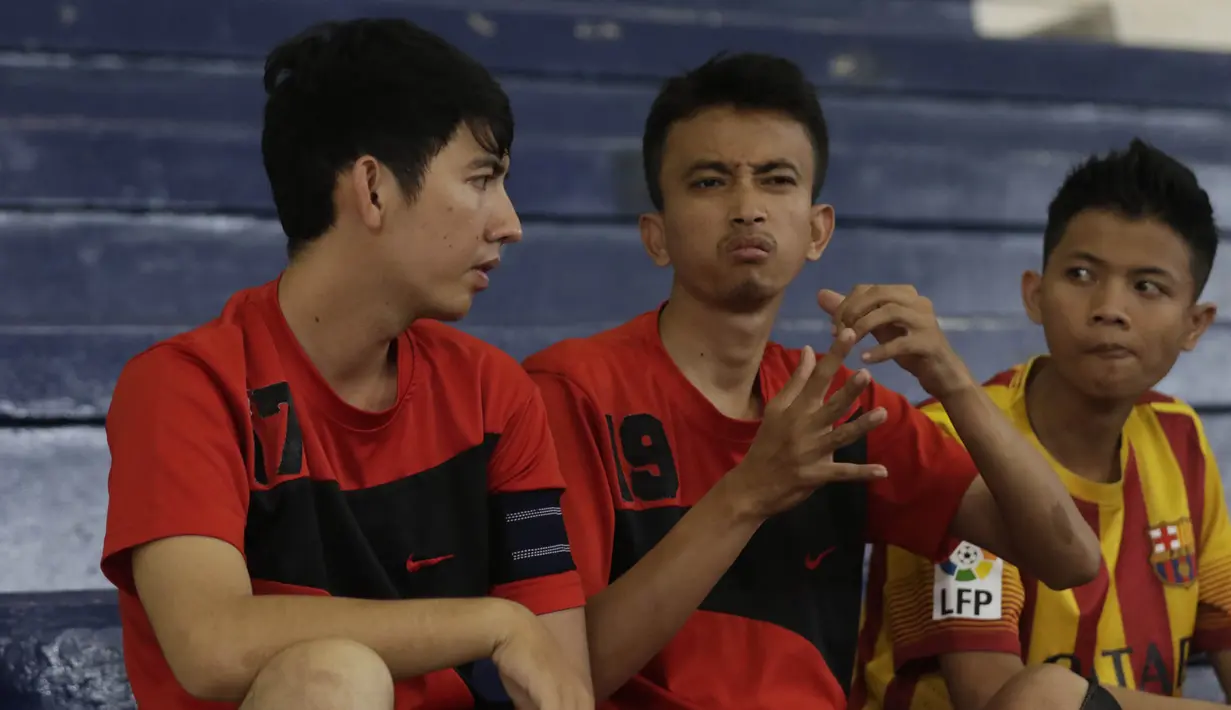 Para pesepak bola tuna rungu berdiskusi menggunakan bahasa isyarat saat akan bertanding pada Kejuaraan Futsal Tuna Rungu di GOR Ciracas, Jakarta, Sabtu (7/11/2015). (Bola.com/Vitalis Yogi Trisna)