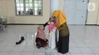 Guru melakukan pengukuran tinggi dan berat badan  murid kelas 1  saat kegiatan Bulan Imunisasi Anak Sekolah (BIAS) di SDI Al-Hidayah, Depok, Jawa Barat, Kamis (18/11/2021).  Sebanyak 100.719 siswa kelas I, II, dan V SD atau MI sederajat menjadi sasaran pemberian imunisasi. (merdeka.com/Arie Basuki)