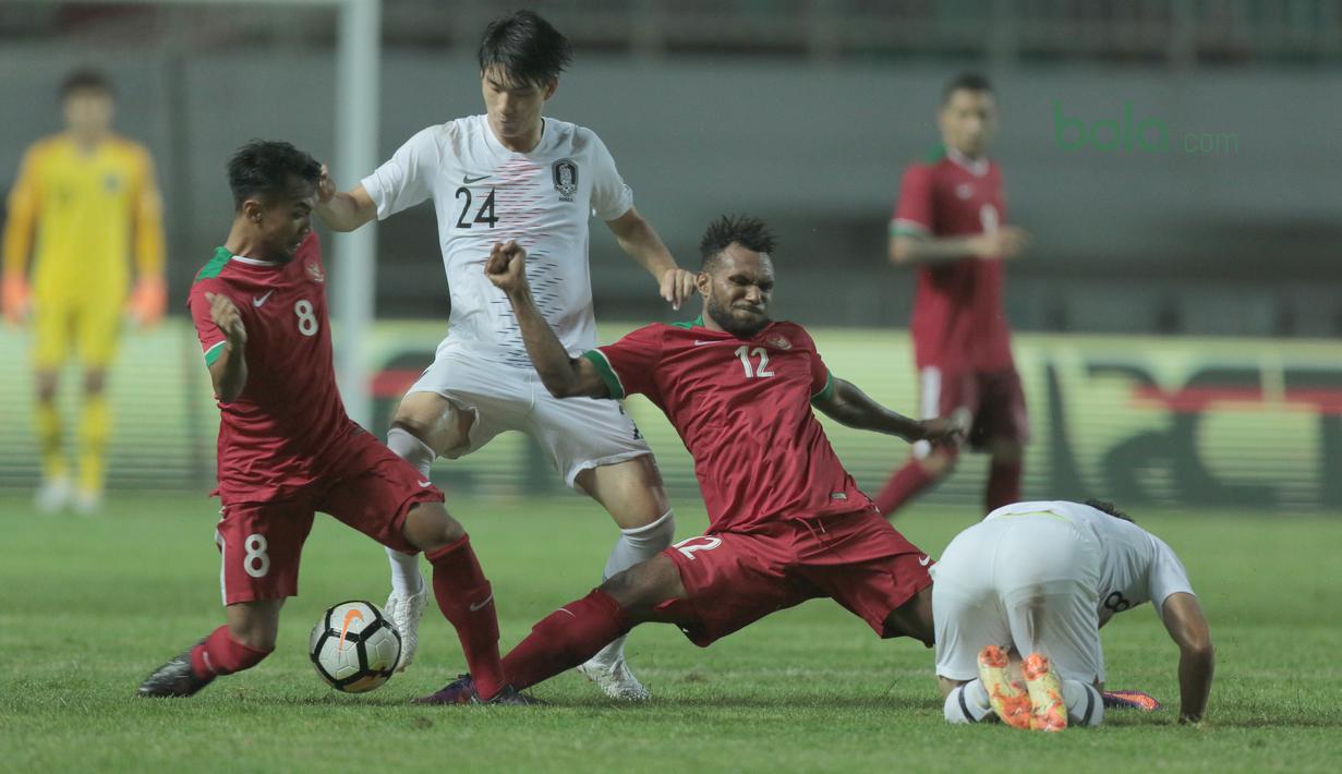 Pemain Timnas Indonesia, Nelson Alom (2kanan) dan Hargianto berebut bola dengan pemain Korea Selatan U-23 pada laga uji coba di Stadion Pakansari, Bogor, (23/6/2018).  Indonesia U-23 kalah 1-2 dari Korea U-23. (Bola.com/Nick Hanoatubun)