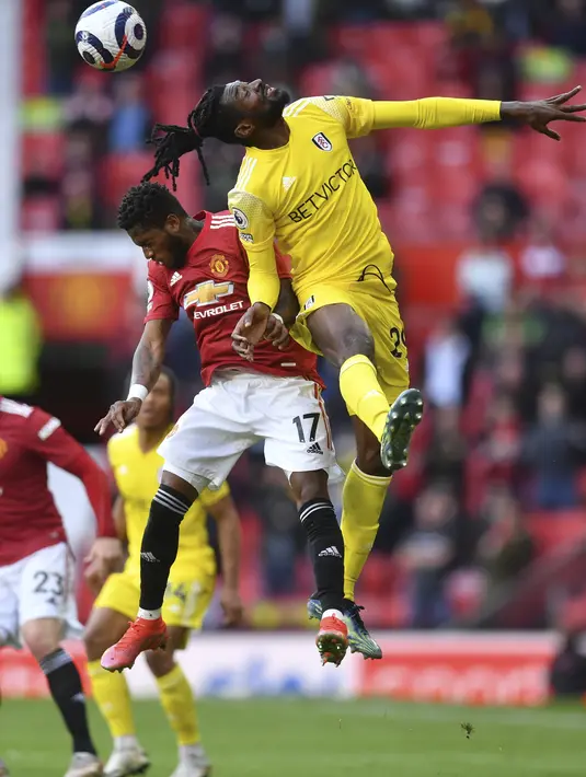 Gelandang Manchester United (MU), Fred berebut bola dengan gelandang Fulham, Andre-Frank Zambo Anguissa pada pekan 37 Liga Inggris di Stadion Old Trafford, Rabu (19/5/2021) dinihari WIB. MU kembali gagal menang setelah ditahan imbang 1-1 oleh tamunya Fulham. (AP Photo/Paul Ellis, Pool)