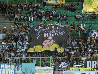Suporter Laskar Joko Tingkir membentangkan bendera bergambar alm Choirul Huda saat menyaksikan laga Persela melawan Bhayangkara FC di Stadion Patriot Candrabhaga, Bekasi, Jumat (27/10). (Liputan6.com/Helmi Fithriansyah)