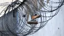Sepasang sepatu di kawat berduri di penjara Mulhouse (Maison d'arret), Prancis timur (22/10/2021). Penjara Mulhouse mirip dengan penjara county di Amerika Serikat yang menahan tahanan kurang dari satu tahun. (AFP/Frederick Florin)