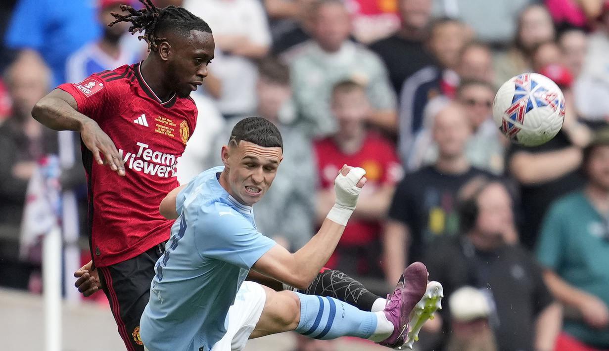 Bek Manchester United, Aaron Wan-Bissaka (kiri) berusaha menghalau bola dari ancaman gelandang Manchester City, Phil Foden pada laga final Piala FA 2023/2024 di Wembley Stadium, London, Sabtu (25/5/2024). (AP Photo/Kin Cheung)