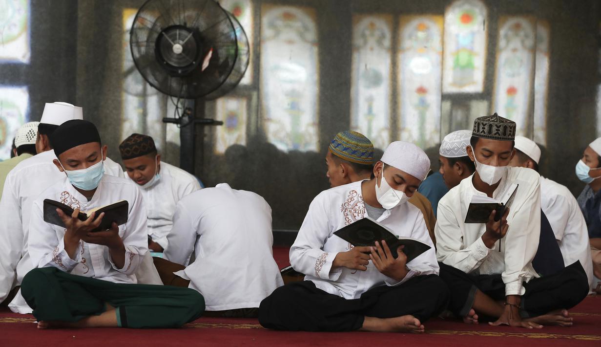 Para siswa mengenakan masker untuk membantu mengekang penyebaran COVID-19 saat membaca kitab suci Alquran di Masjid Attaqwa, Bekasi, Jawa Barat, Selasa (4/5/2021). Selama Ramadhan, umat muslim menahan diri dari makan, minum, merokok dan seks dari subuh hingga maghrib. (AP Photo/Achmad Ibrahim)