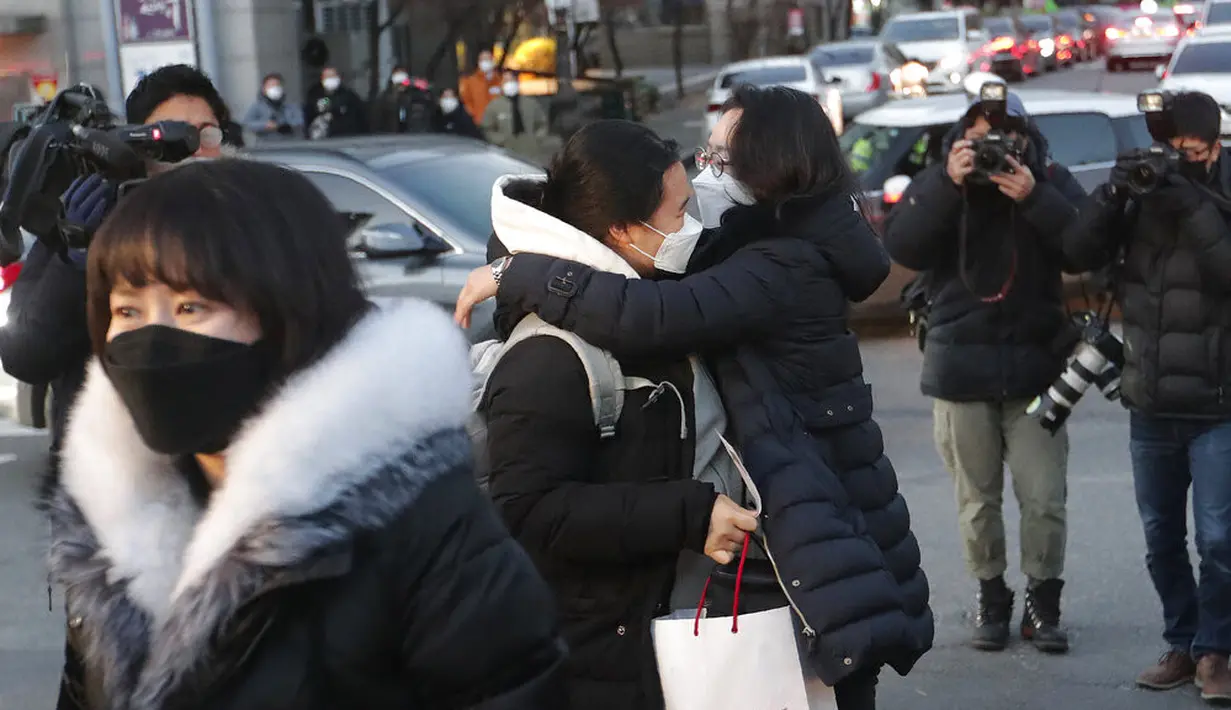 Seorang siswa memeluk ibunya (tengah) sebelum masuk sekolah menengah untuk mengikuti ujian masuk perguruan tinggi di Seoul, Korea Selatan, Kamis (3/12/2020). Pejabat Korea Selatan mendesak orang-orang untuk tetap di rumah selama ujian masuk perguruan tinggi. (AP Photo/Ahn Young-joon)